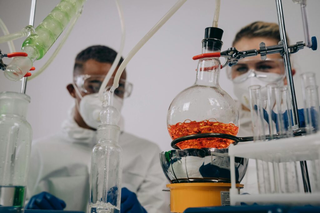 Two scientists in protective gear conducting experiments in a laboratory setting.